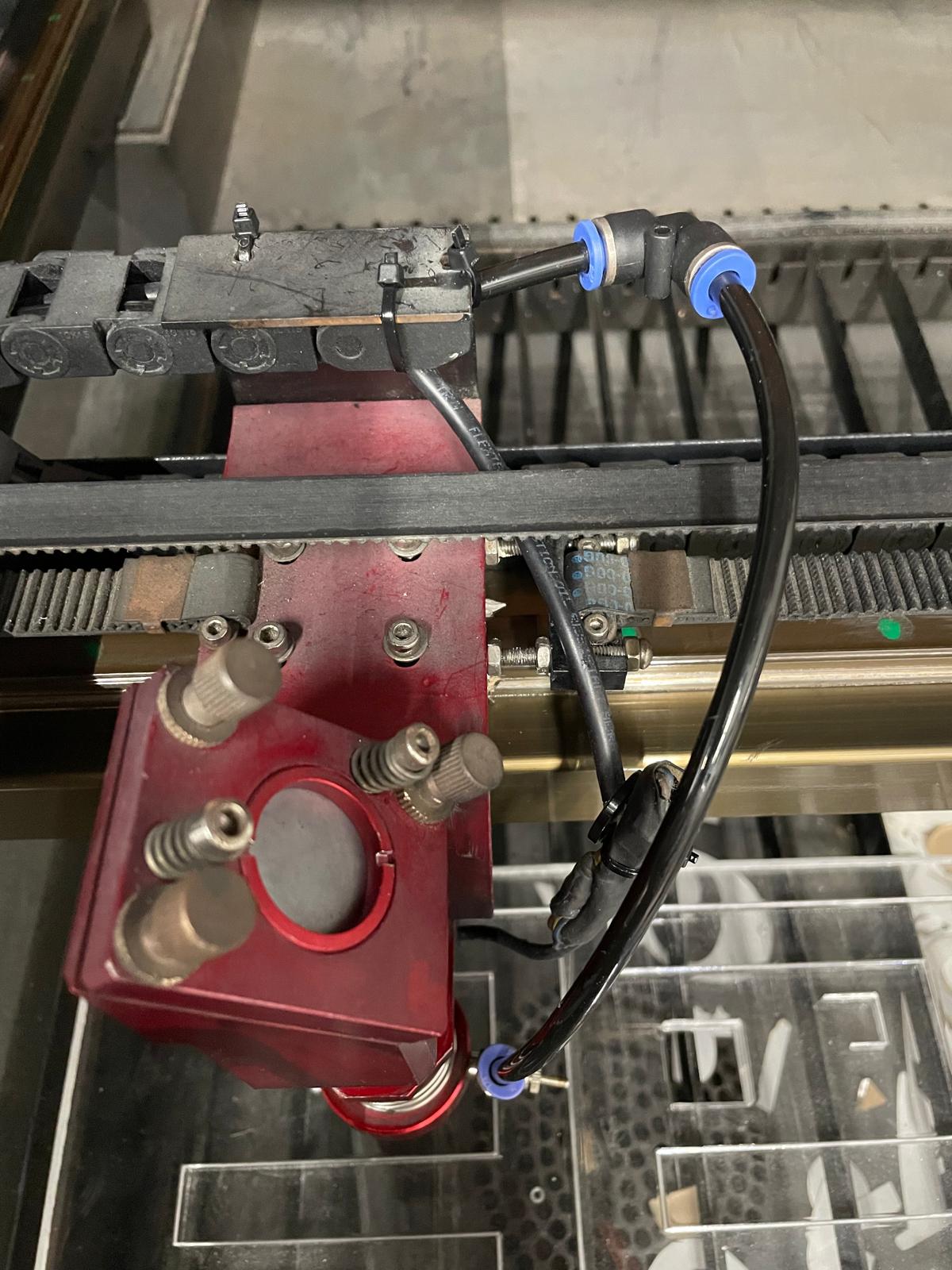 Cabezal láser CNC con mangueras de aire durante el mantenimiento